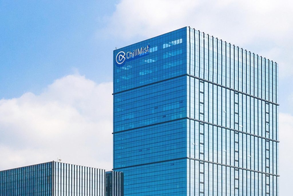 chillmist logo on a modern glass office building against a blue sky with clouds